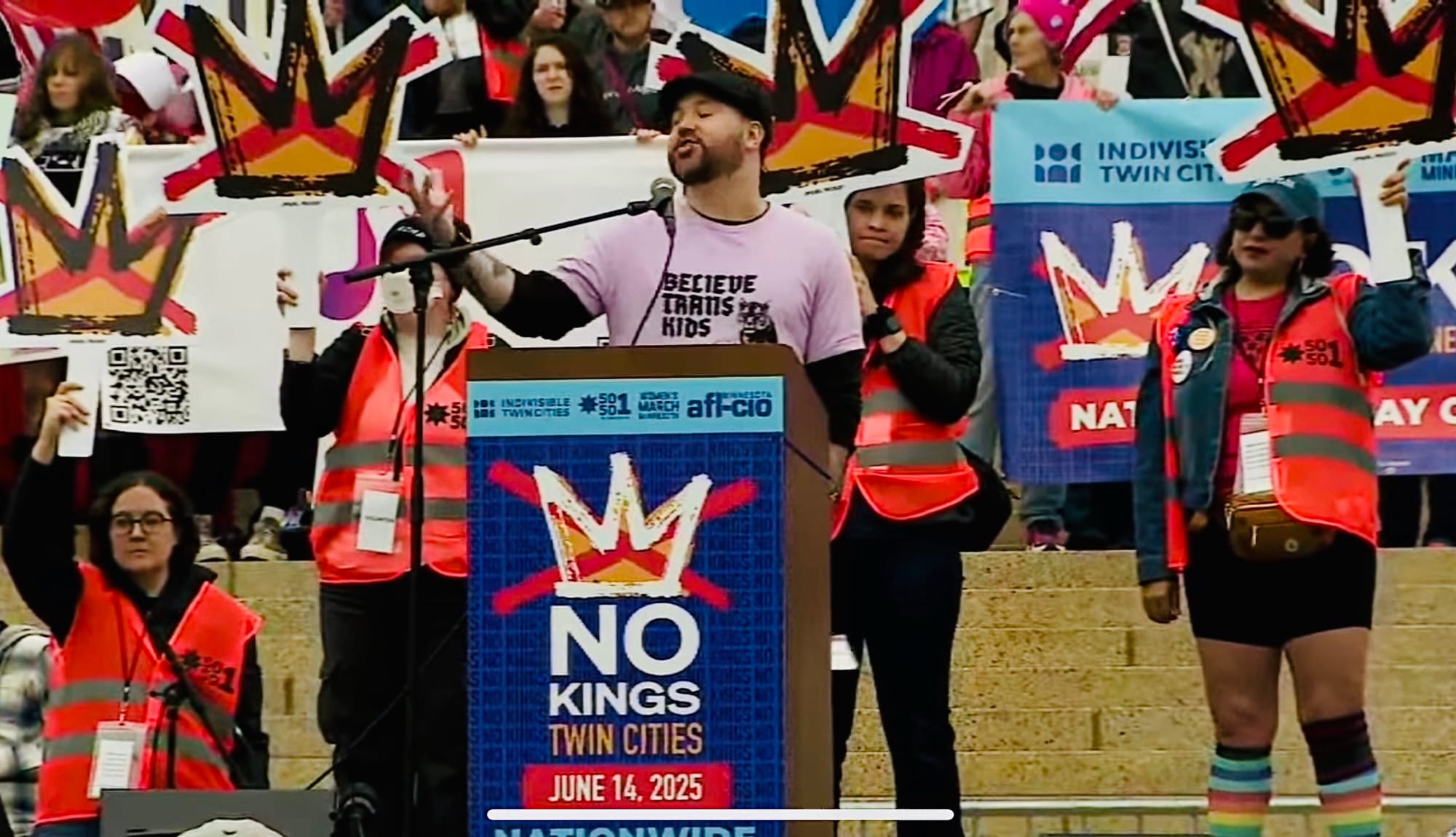 a photo of KTM performing at a podium that says "no kings twin cities"